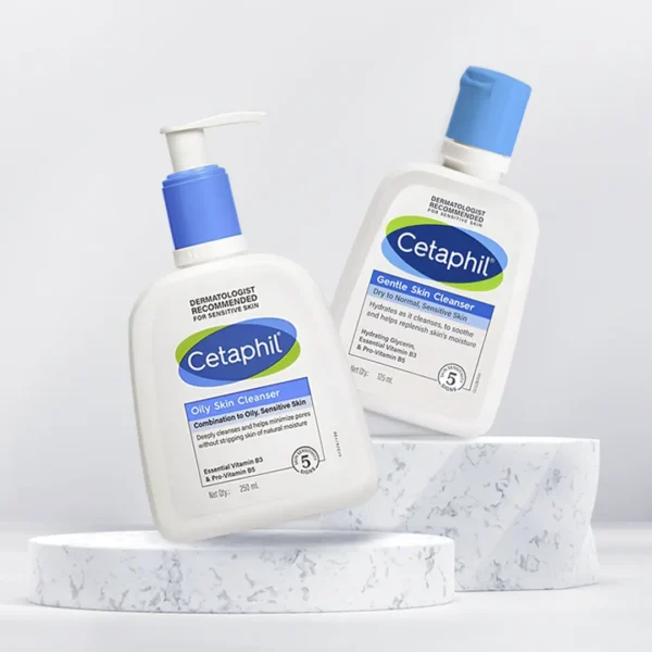 Two Cetaphil skin cleansers on a marble pedestal: Oily Skin Cleanser and Gentle Skin Cleanser, labeled for sensitive skin types.